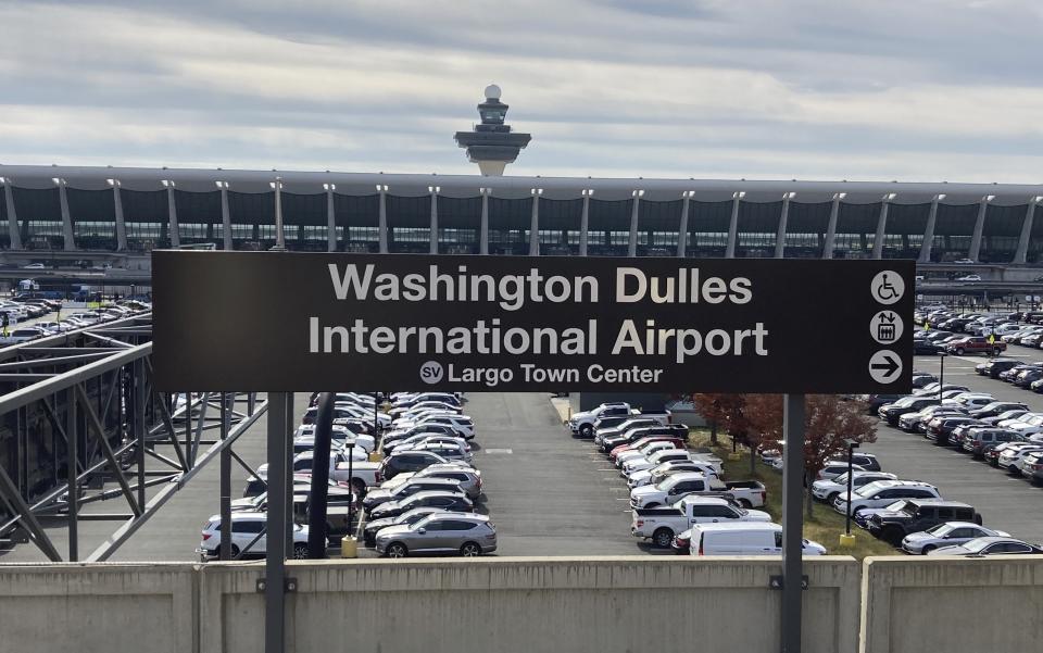 The Metrorail station at Dulles International Airport is seen on Nov. 2, 2022, in Chantilly, Va., with the terminal in the background. The Washington Metropolitan Area Transit Authority is ready to open the second and final phase of its Silver Line Metrorail extension on Nov. 15. The six new stations will for the first time connect the airport and the outer suburbs of Loudoun County to the region's flagship mass transit system. (AP Photo/Matthew Barakat)