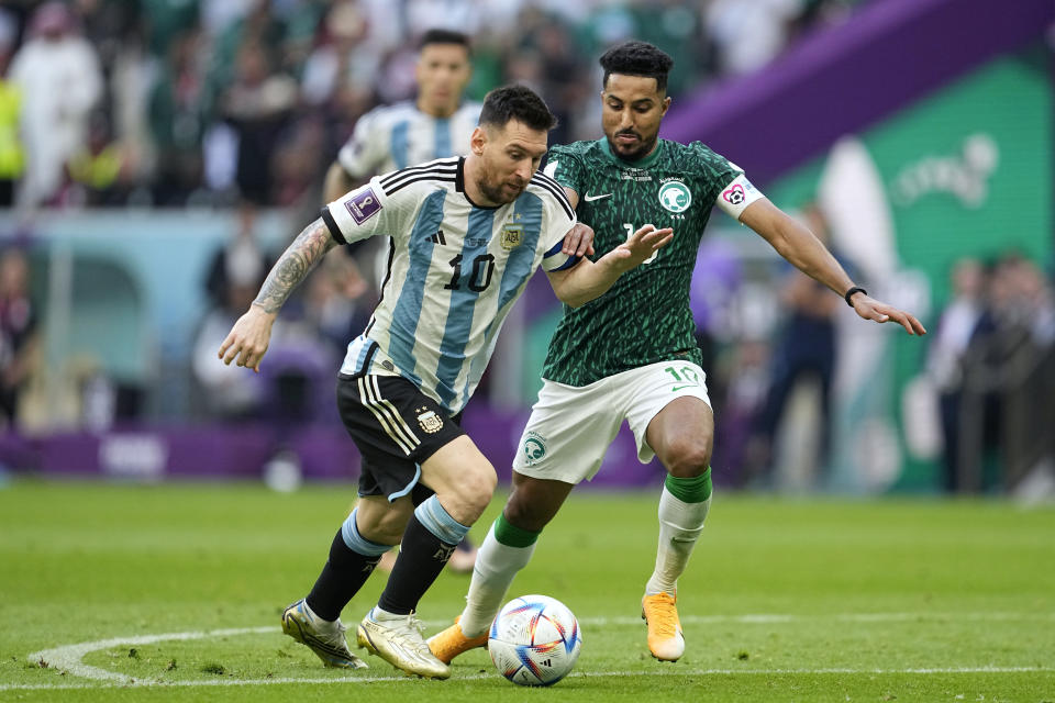 Argentina's Lionel Messi,left, and Saudi Arabia's Salem Al-Dawsari, fight for the ball during the World Cup group C soccer match between Argentina and Saudi Arabia at the Lusail Stadium in Lusail, Qatar, Tuesday, Nov. 22, 2022. (AP Photo/Ebrahim Noroozi)