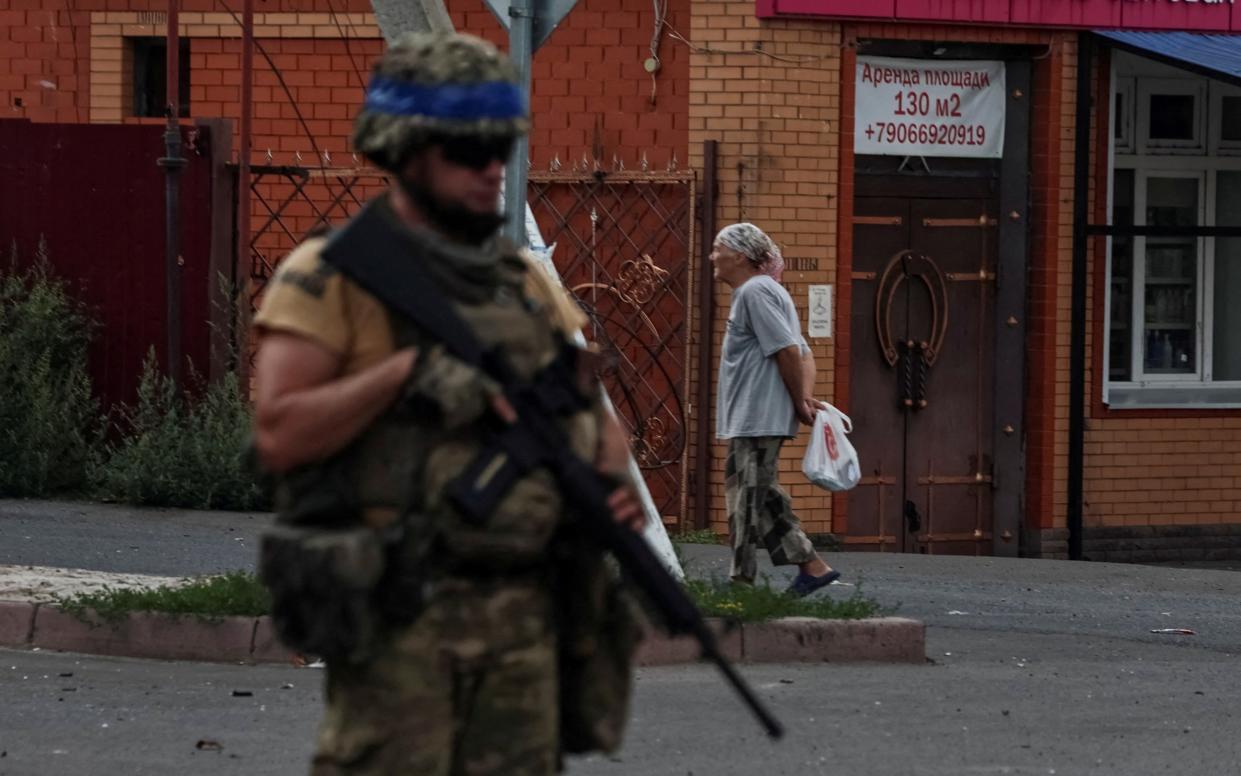 A Ukrainian serviceman patrols an area in the controlled by Ukrainian army town of Sudzha, Kursk region