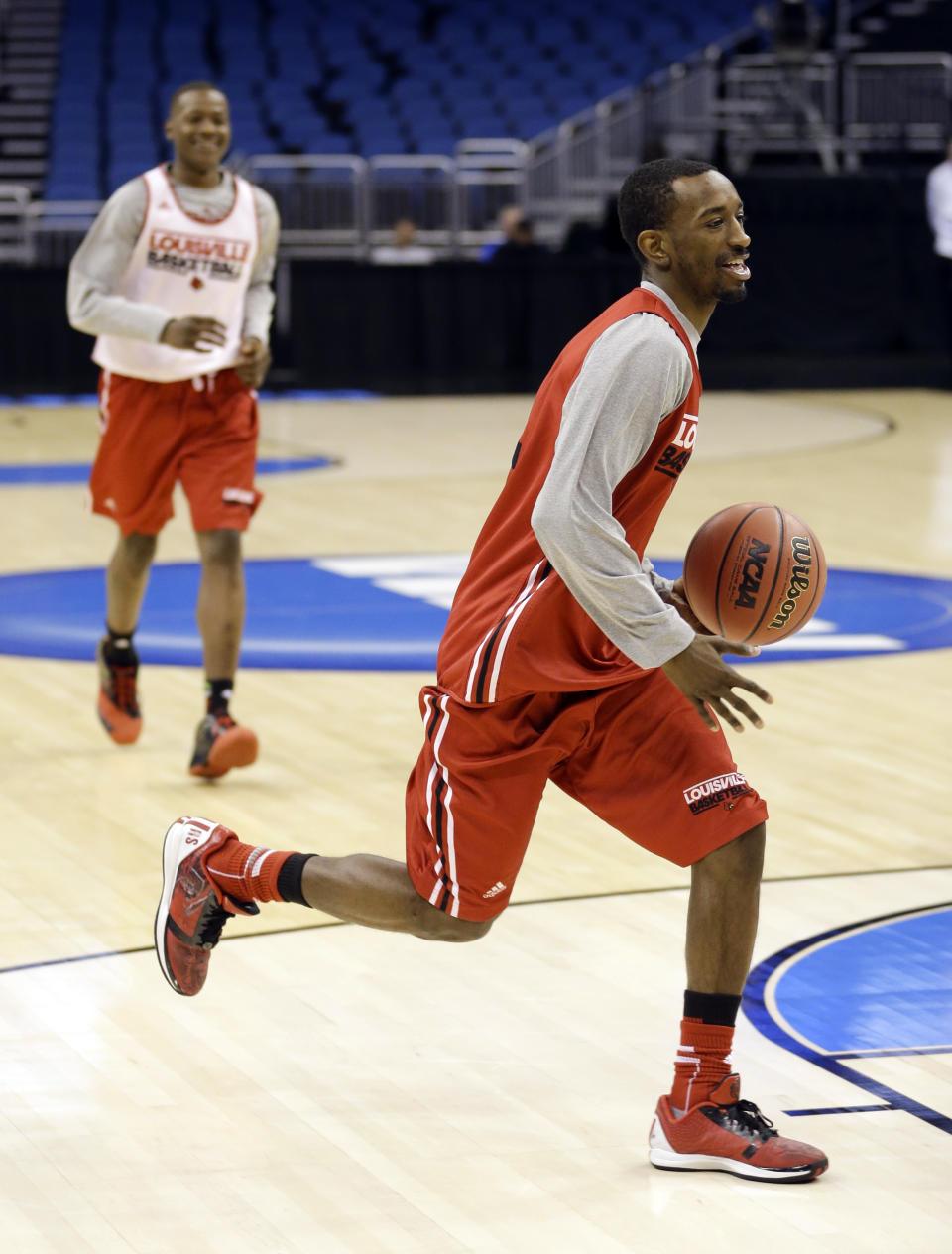 Louisville's Russ Smith, right, takes the ball to the basket during practice for the NCAA men's college basketball tournament in Orlando, Fla., Wednesday, March 19, 2014. Louisville plays against Manhattan in a second-round game on Thursday. (AP Photo/John Raoux)