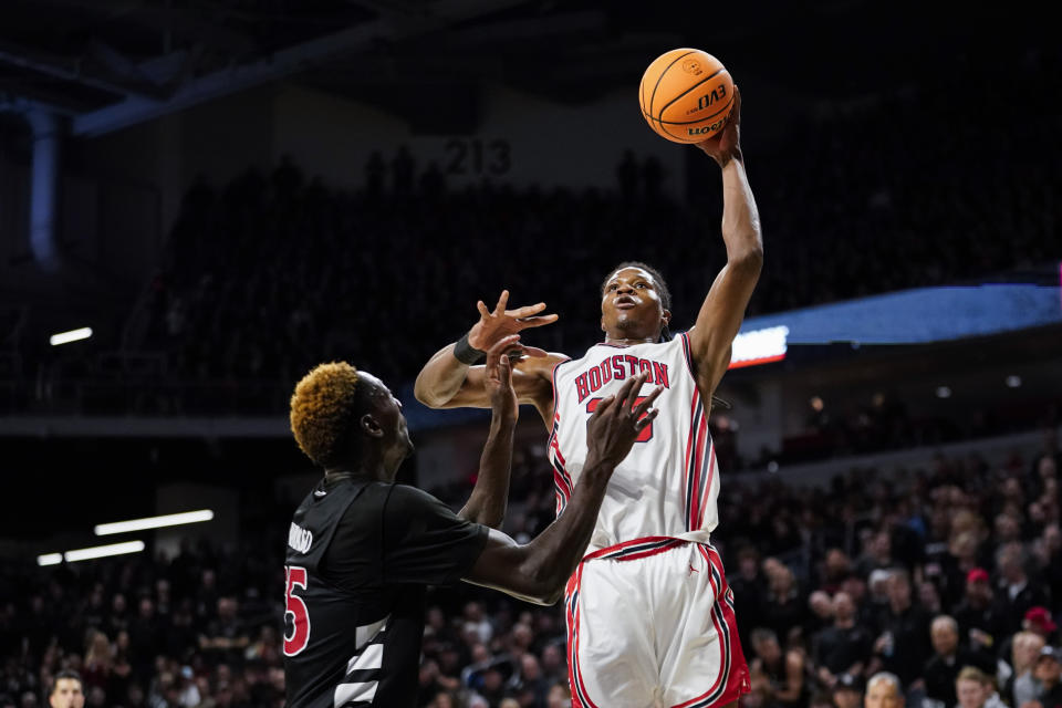 Houston forward Joseph Tugler, right, attempts a layup over Cincinnati forward Aziz Bandaogo, left, during the second half of an NCAA basketball game, Saturday, Feb. 10, 2024, in Cincinnati. (AP Photo/Joshua A. Bickel)