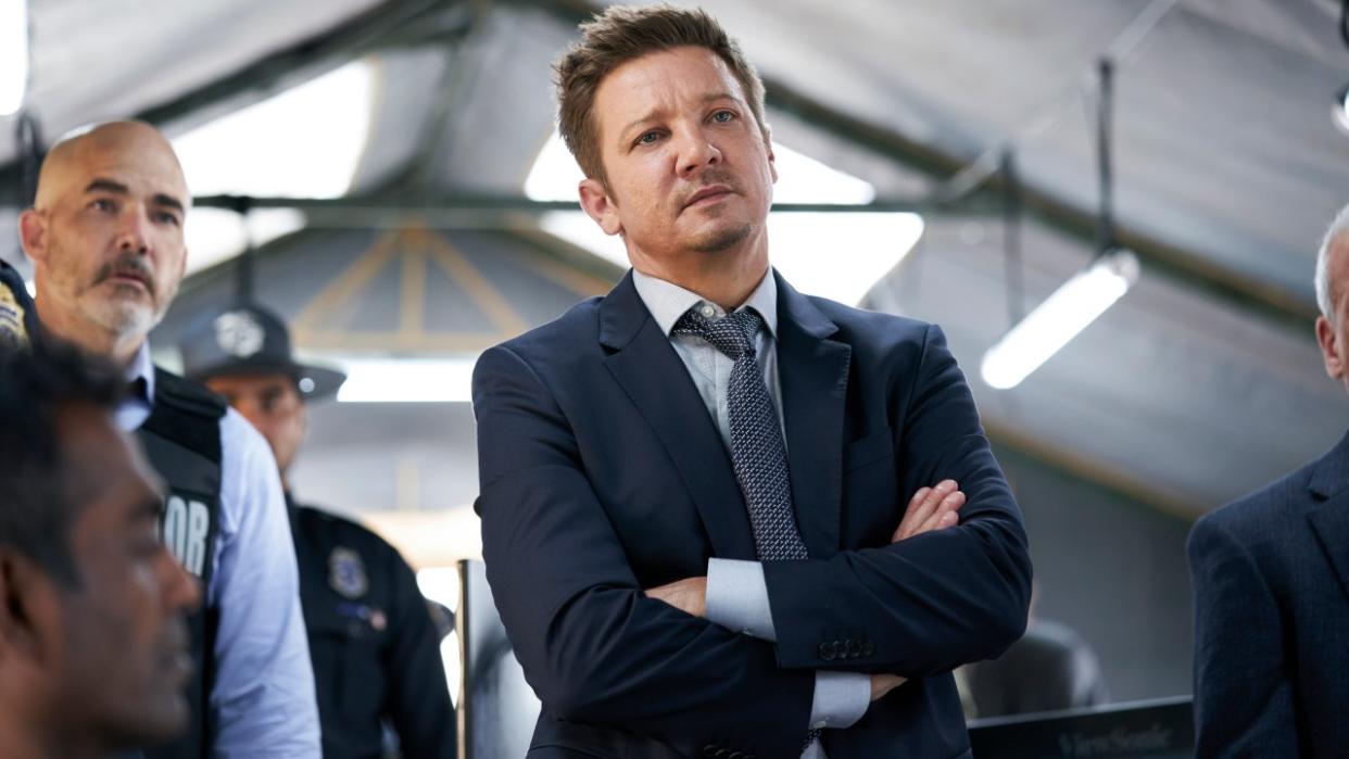  Jeremy Renner standing with his arms crossed in Mayor of Kingstown 