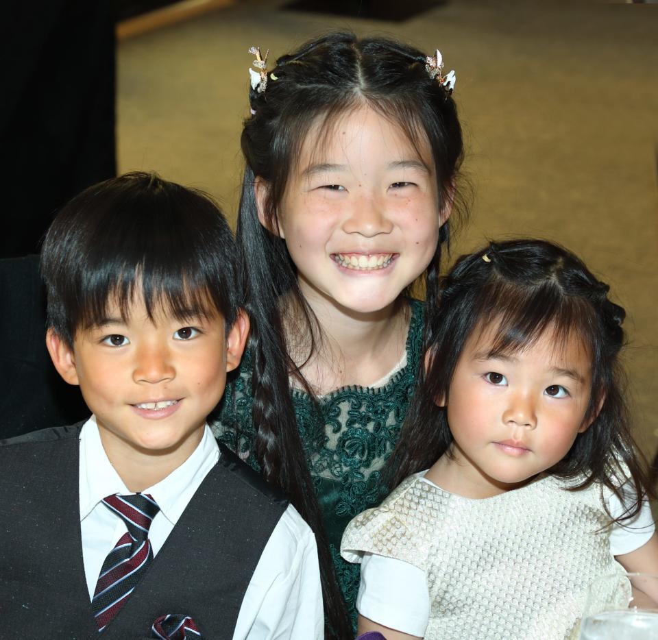 Young pianist Queenie Chen (center), here with siblings Tyler and Wilhelmina, beams with pride after her rendition of “Tarantella” at the music event.