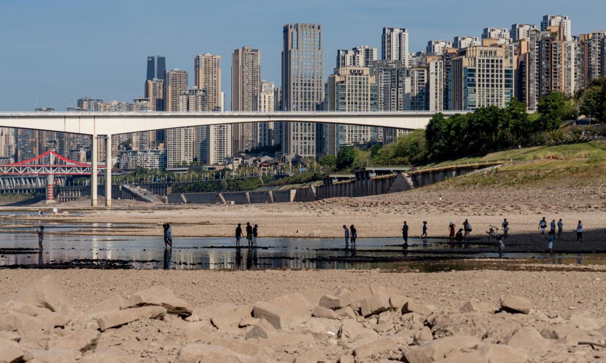 <span>People walk on a dried-out riverbed in Chongqing, China, in August 2022. One study says China is on track for between 20,000 and 80,000 heatwave deaths a year.</span><span>Photograph: EPA</span>