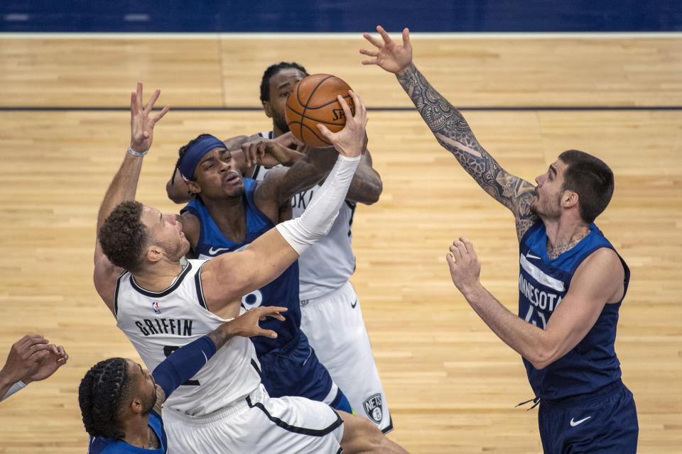 Brooklyn Nets forward Blake Griffin, left, is fouled by Minnesota Timberwolves forward Jarred Vanderbilt, center, as Timberwolves forward Juancho Hernangomez, right, tries to block his shot during the first half of an NBA basketball game Tuesday, April 13, 2021, in Minneapolis. (AP Photo/Craig Lassig)