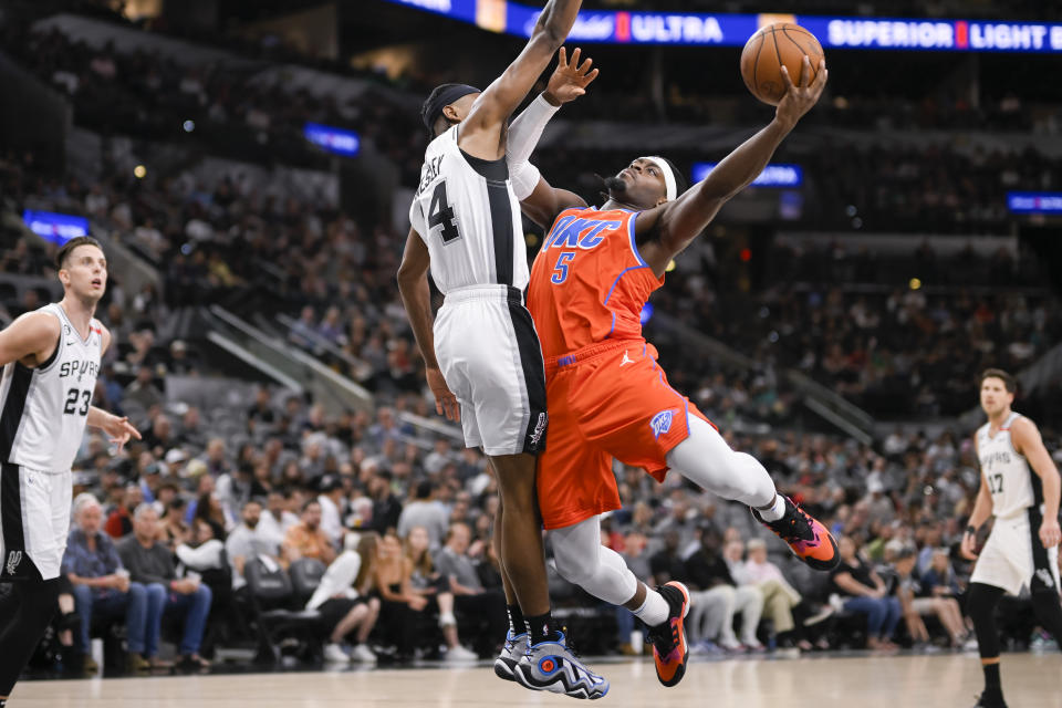 Oklahoma City Thunder's Luguentz Dort (5) goes to the basket against San Antonio Spurs' Blake Wesley during the first half of an NBA basketball game, Sunday, March 12, 2023, in San Antonio. (AP Photo/Darren Abate)