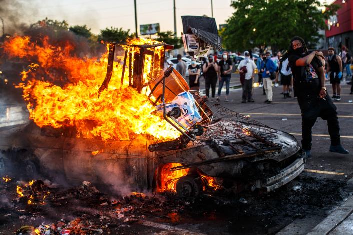 Protesters throw objects into a fire outside a Target store near the Third Police Precinct on May 28, 2020 in Minneapolis, Minnesota, during a demonstration over the death of George Floyd. (Photo by Kerem Yucel / AFP) (Photo by KEREM YUCEL/AFP via Getty Images)