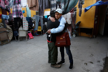 Honduran migrant Ariel, 19, who is waiting for his court hearing for asylum seekers, that have been returned to Mexico to await their legal proceedings under a new policy established by the U.S. government, embraces a man at a shelter in Tijuana, Mexico, March 19, 2019. REUTERS/Jorge Duenes