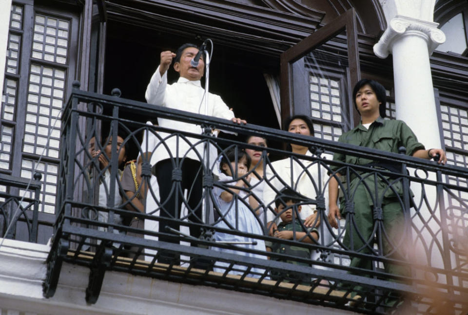 Philippine President Ferdinand Marcos delivering his last speech to supporters from the balcony of Malacanang Palace in Manila in February 1986 before the family was forced to flee aboard American helicopters following a people's movement. His son and future leader Bongbong is standing far right.<span class="copyright">Alex Bowie–Getty Images</span>