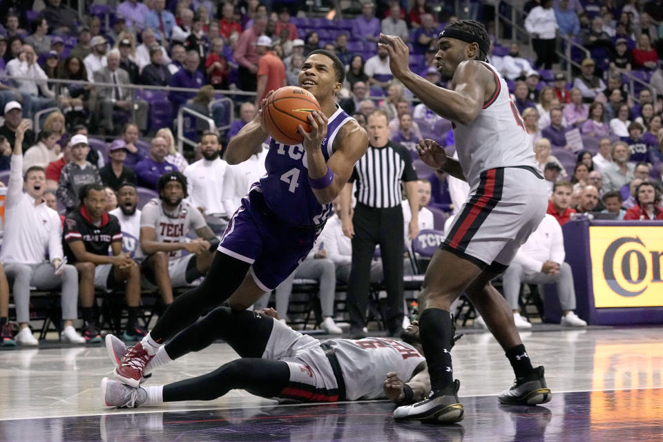 TCU guard Jameer Nelson Jr. (4) is tripped on a drive to the basket by Texas Tech 's Joe Toussaint, bottom, as Robert Jennings, right, helps defend on the play in the first half of an NCAA college basketball game in Fort Worth, Texas, Tuesday, Jan. 30, 2024. (AP Photo/Tony Gutierrez)