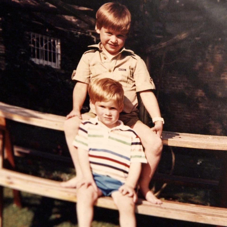 Prince William and Prince Harry on a picnic bench in a snap from a family album - Credit: The Duke of Cambridge and Prince Harry.