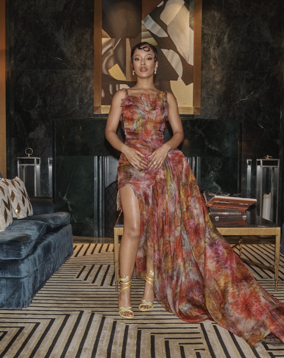 a woman wearing a floral dress in a hotel suite