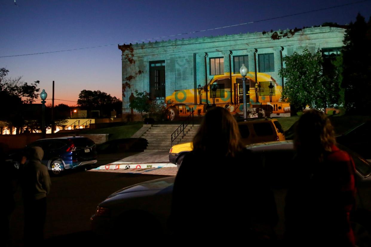 First Friday goers watch a projection on the Wells Community Cultural Center, Friday, May 7, 2021 in Lafayette.