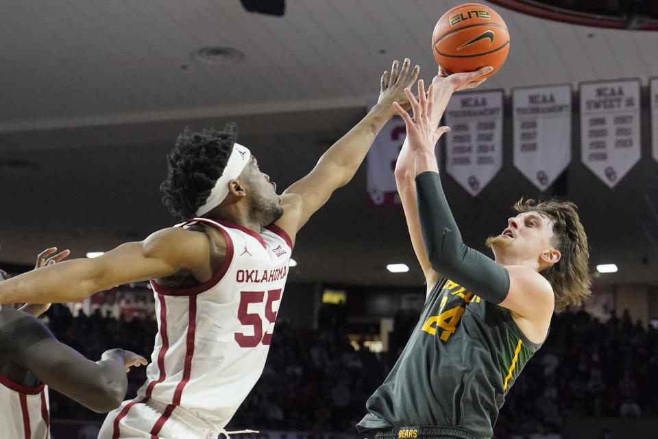 Baylor guard Matthew Mayer (24) shoots as Oklahoma guard Elijah Harkless (55) defends in the first half of an NCAA college basketball game Saturday, Jan. 22, 2022, in Norman, Okla. (AP Photo/Sue Ogrocki)