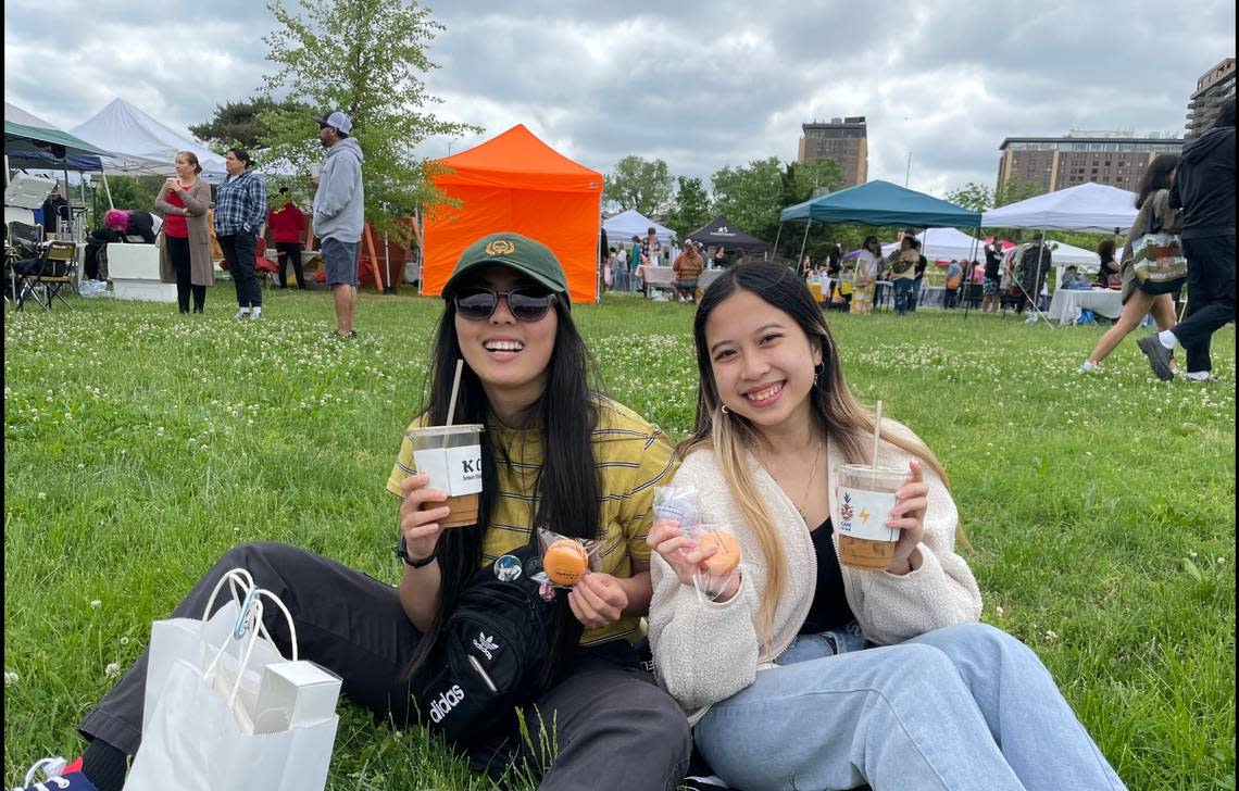Kelly Chung and Erica Pham sit among hundreds attending Cafe Cà Phê’s Asian American and Pacific Islander heritage month celebration in Columbus Park.