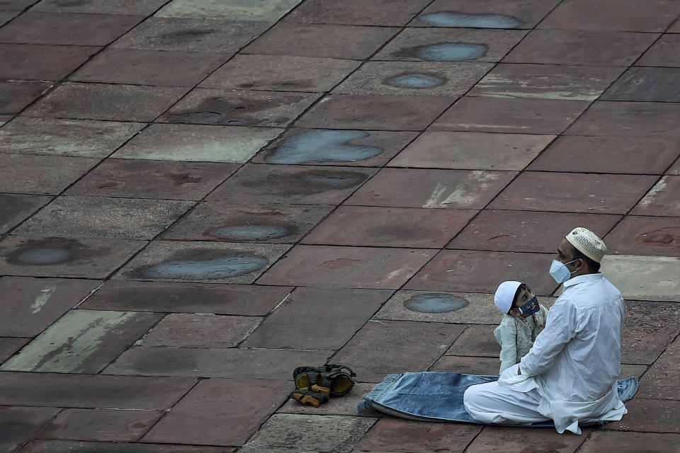 A Muslim father and his son wait to offer a special morning prayer to kick off the Eid al-Adha, the feast of sacrifice, at Jama Masjid mosque in New Delhi on August 1, 2020. (Photo by Money SHARMA / AFP) (Photo by MONEY SHARMA/AFP via Getty Images)