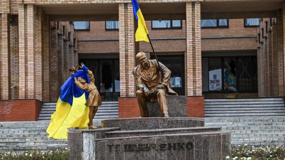 Una fotografía tomada el 10 de septiembre de 2022 muestra banderas ucranianas colocadas sobre estatuas en una plaza en Balakleya, región de Járkov, en medio de la invasión rusa de Ucrania. Las fuerzas ucranianas dijeron el 10 de septiembre de 2022 que habían ingresado a la ciudad de Kupyansk en el este de Ucrania, desalojando a las tropas rusas de un centro logístico clave en una contraofensiva relámpago que ha visto recuperar franjas de territorio.