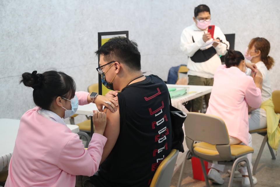 第12輪COVID-19公費疫苗開放施打，指揮中心在台北市增設5處接種地點，當代文化實驗場23日施打，民眾一早前往接種站施打公費疫苗。（中央社）