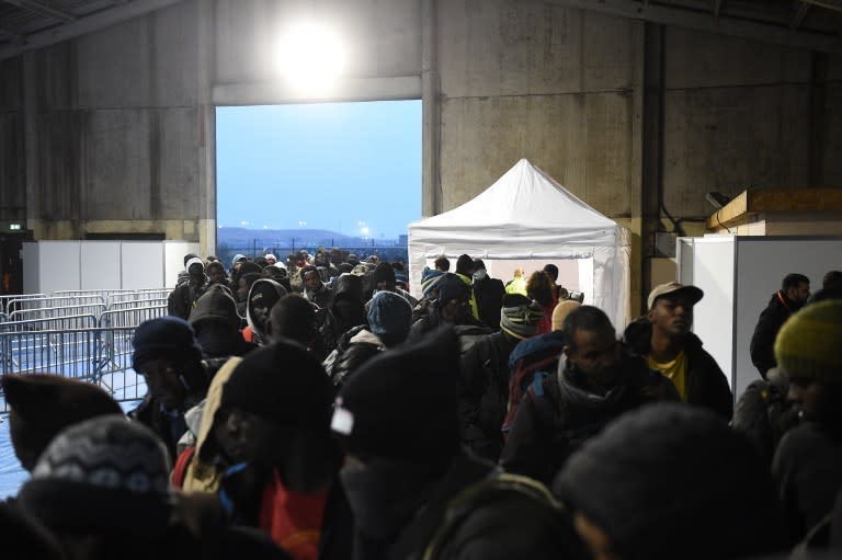 Le hangar qui fait office de centre de transit ouvre enfin ses portes. À l’intérieur, les individus sont répartis en quatre files distinctes : familles, adultes seuls, mineurs isolés et personnes vulnérables. (AFP)