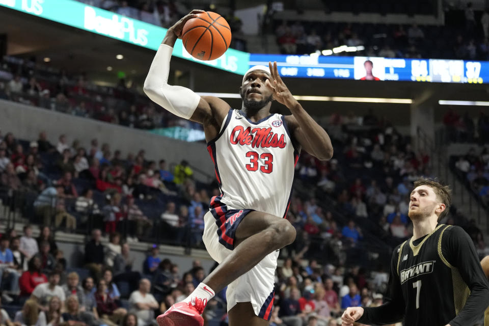 Mississippi forward Moussa Cisse (33) leaps toward the basket as he attempts a layup past Bryant forward Connor Withers (7) during the second half of an NCAA college basketball game Sunday, Dec. 31, 2023, in Oxford, Miss. (AP Photo/Rogelio V. Solis)