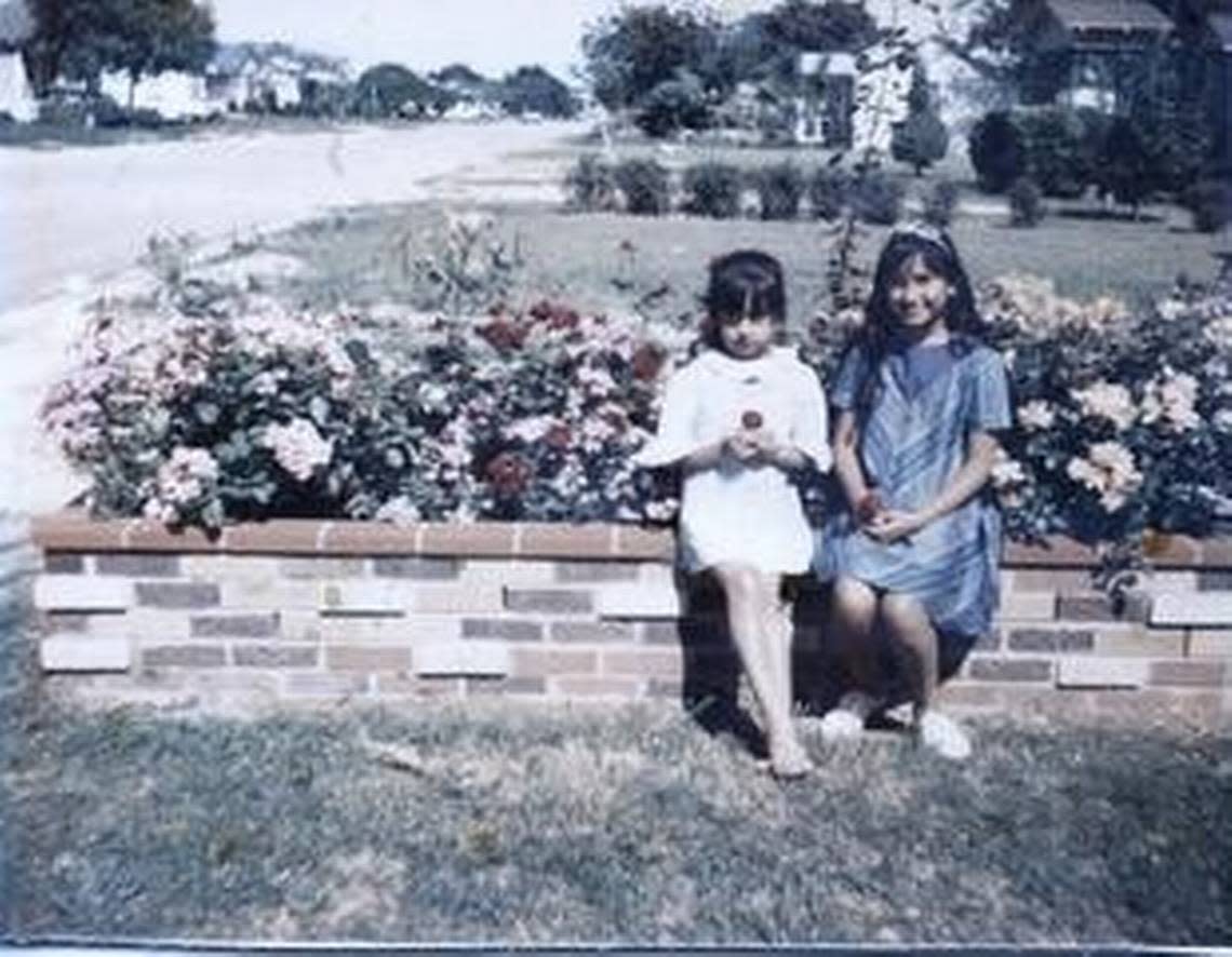 Anita Vasquez, 6, left, and her sister Rosemary Galdiano, 11, sit in front of their house on Drew Street in Worth Heights, 1966.