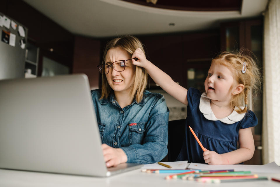 woman working from home while kid messes with her glasses