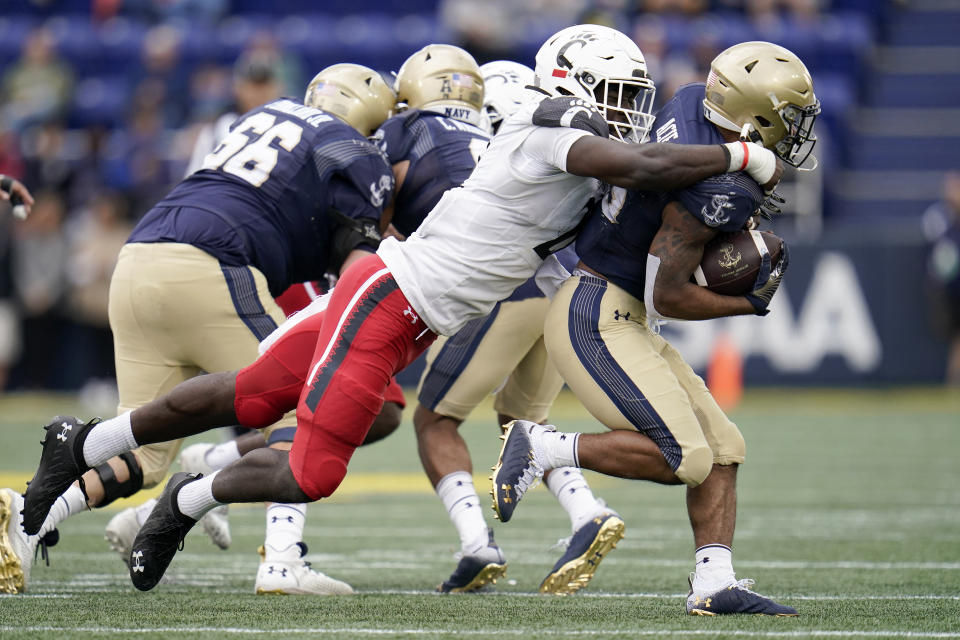 Cincinnati defensive lineman Myjai Sanders, left, tackles Navy fullback Carlinos Acie during the second half of an NCAA college football game, Saturday, Oct. 23, 2021, in Annapolis, Md. Cincinnati won 27-20. (AP Photo/Julio Cortez)