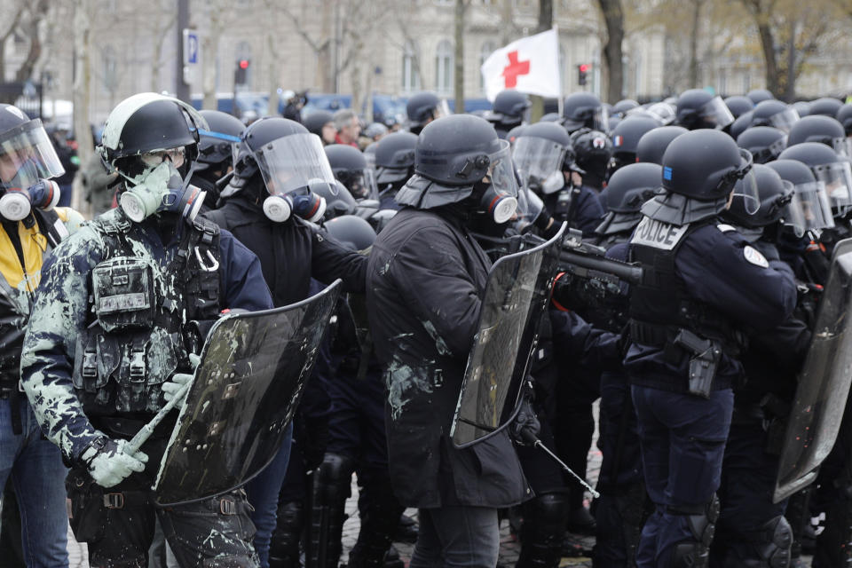 Riot police take position during clashes yellow vest protesters clash around the Arc of Triomphe in Paris, France, Saturday, Jan. 12, 2019. Authorities deployed 80,000 security forces nationwide for a ninth straight weekend of anti-government protests. (AP Photo/Kamil Zihnioglu)