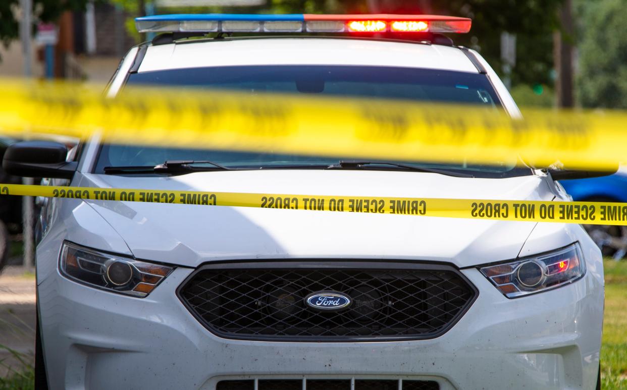 Crime scene tape near a squad car. 