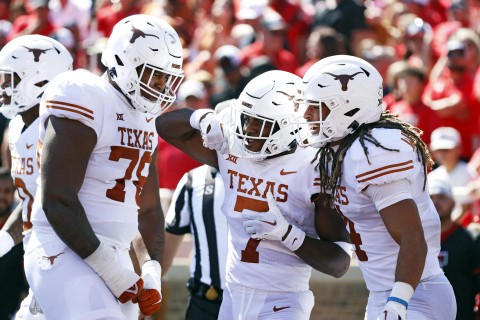 Texas’ Keilan Robinson (7) celebrates with Kelvin Banks Jr. (78) and Austin Jordan (4) after scoring a touchdown during the first half of an NCAA college football game against Texas Tech, Saturday, Sept. 24, 2022, in Lubbock, Texas. AP Photo/Brad Tollefson<strong> <br></strong>
