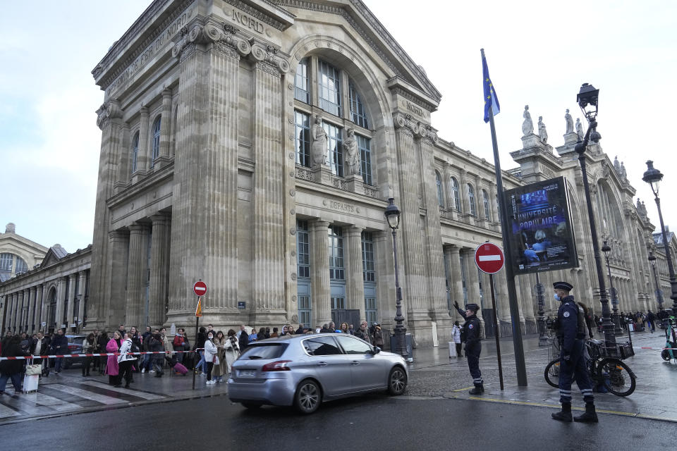 People wait behind the police tape outside the Gare du Nord train station, Wednesday, Jan. 11, 2023 in Paris. French media are reporting that people have been stabbed at a Paris train station and the interior minister says several people were injured before police "rapidly neutralized" the attacker. (AP Photo/Michel Euler)