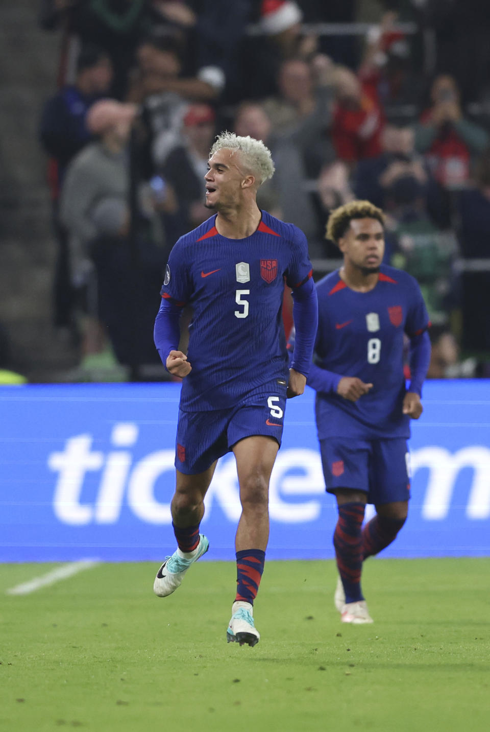 U.S. defender Antonee Robinson (5) celebrates scoring against Trinidad and Tobago with midfielder Weston McKennie (8) during the second half of the first leg of a CONCACAF Nations League soccer quarterfinal Thursday, Nov. 16, 2023, in Austin, Texas. (AP Photo/Stephen Spillman)