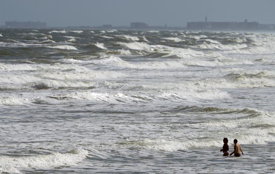 A pair of beachgoers brave the rough surf on Monday in Daytona Beach, where the initial effects of Subtropical Storm Nicole were evident long before its expected approach on Wednesday. Volusia and Flagler county officials urged residents to prepare now.