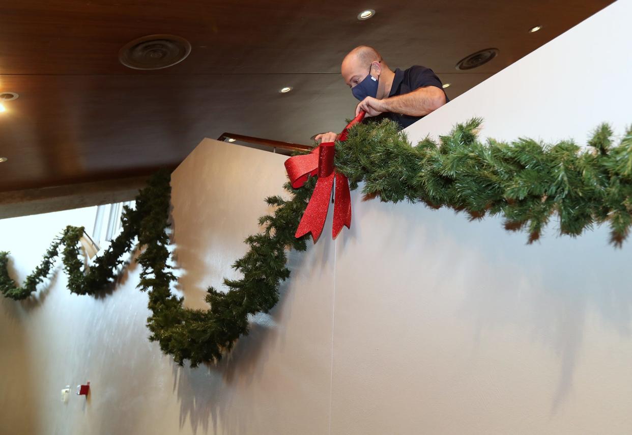 Dominic Cardarelli, senior account manager at E.J. Thomas Hall, decorates the lobby of the theater on the University of Akron campus Friday in Akron. A new agreement joins the booking operations, operational strategy and event oversight of E.J. Thomas with those at the Akron Civic and Goodyear theaters.