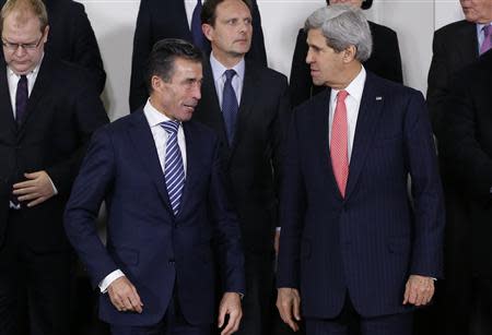 NATO Secretary General Anders Fogh Rasmussen and U.S. Secretary of State John Kerry (R) pose for a family photo during a NATO foreign ministers meeting at the Alliance headquarters in Brussels December 3, 2013. REUTERS/Francois Lenoir