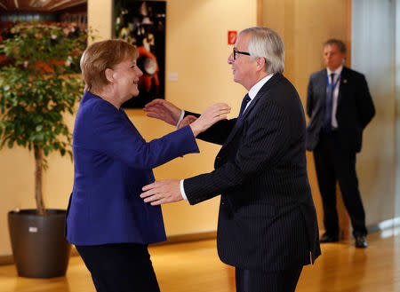 German Chancellor Angela Merkel is welcomed by European Commission President Jean-Claude Juncker at the start of an emergency European Union leaders summit on immigration at the EU Commission headquarters in Brussels, Belgium June 24, 2018. REUTERS/Yves Herman/Pool