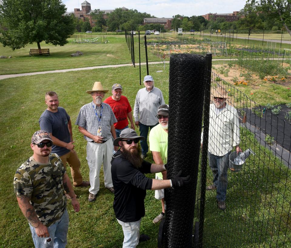 IHM St. Mary's Organic Farm garden coordinator Bob Dluzen (straw hat center left) along with "JAWS" Jail Alternative Work Service members Nick Vanwasshenova, Zach Messer, Anthony Tunison and volunteers Dan Poirier, Dave Gelwicks, Paul Simonton, and Bob Peven  worked on placing a seven foot 70 X 250 foot fence around the  garden this past weekend above behind the IHM.  The reason, deer were eating the 30 gardeners produce, as some gardeners were going to give up on the plots.