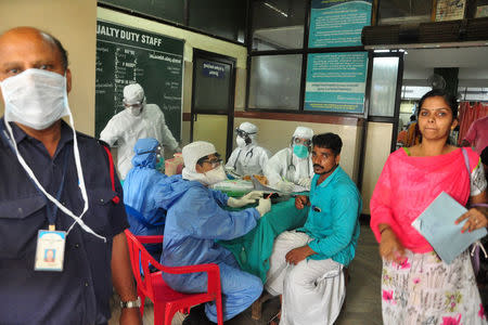 Medics wearing protective gear examine a patient at a hospital in Kozhikode in the southern state of Kerala, India May 21, 2018. REUTERS/Stringer