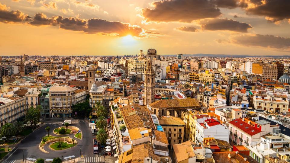 A beautiful view of Valencia from the Torre del Miguelete tower, the sky is yellow-orange under the sunset light.