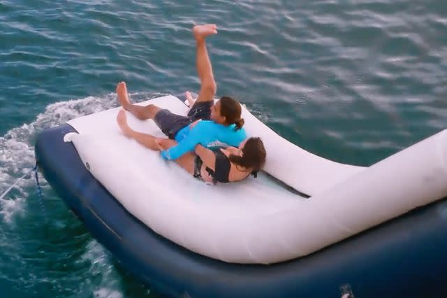 <p>Bravo</p> Two crewmembers go down a water slide