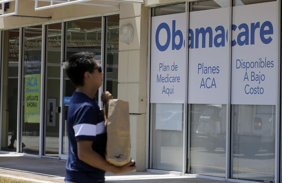 This photo taken Thursday, July 27, 2017, shows a man walks by an healthcare insurance office in Hialeah, Fla. (AP Photo/Alan Diaz)