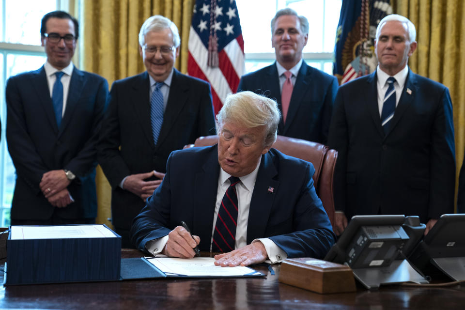 President Donald Trump signed the $2 trillion coronavirus stimulus relief package in the Oval Office at the White House on Friday. (Photo: ASSOCIATED PRESS)