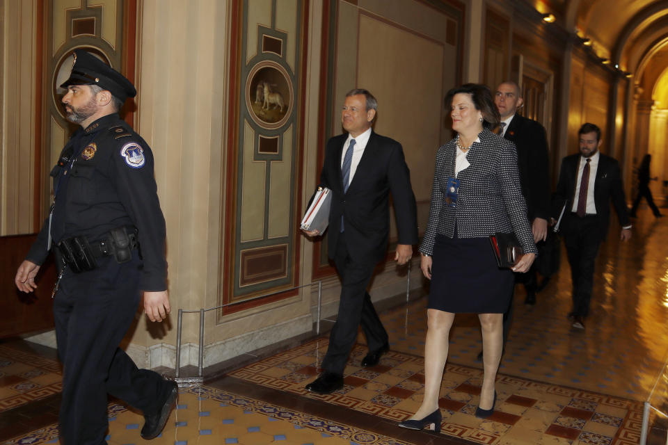 Supreme Court Chief Justice John Roberts, center, arrives at the Capitol Hill in Washington, Tuesday, Jan. 21, 2020. President Donald Trump's impeachment trial quickly burst into a partisan fight Tuesday as proceedings began unfolding at the Capitol. Democrats objected strongly to rules proposed by the Republican leader for compressed arguments and a speedy trial. (AP Photo/Julio Cortez)