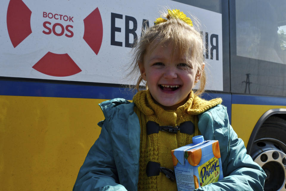 A girl waits to board a transport during an evacuation of civilians on a road near Slovyansk, eastern Ukraine, Wednesday, May 4, 2022. (AP Photo/Andriy Andriyenko)