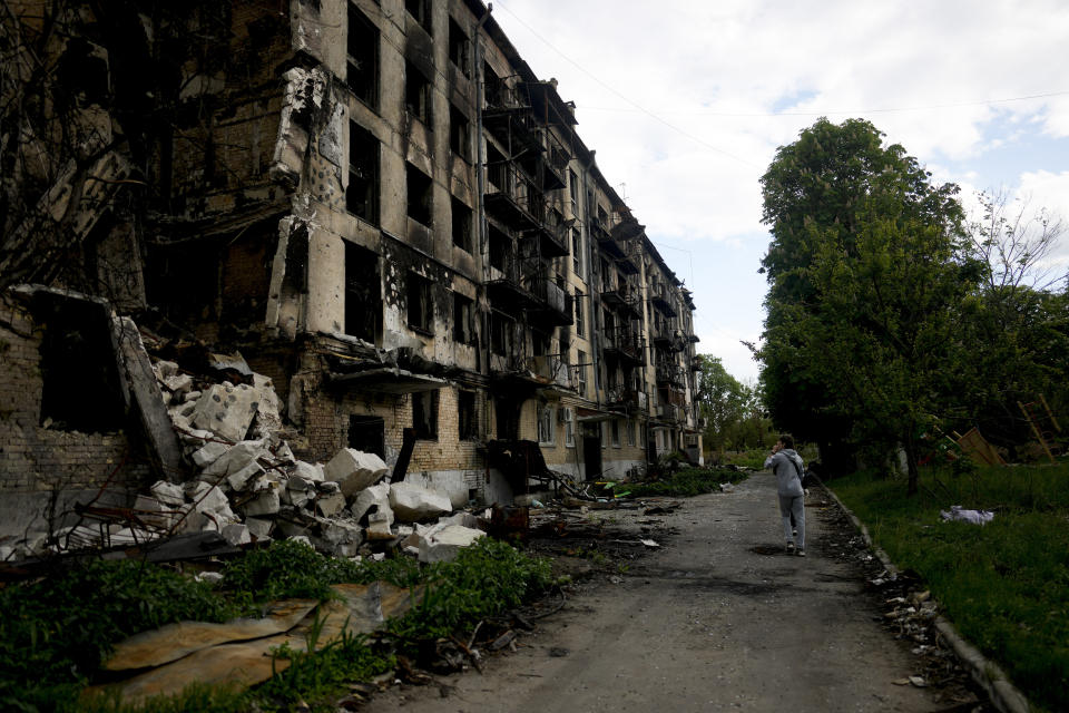 A man walks in front of a damage building ruined by attacks in Hostomel, outskirts Kyiv, Ukraine, Thursday, May 26, 2022. (AP Photo/Natacha Pisarenko)