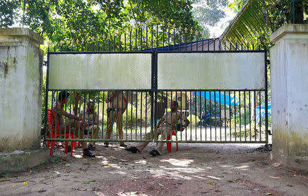 Police officers guard inside the premises of K M Ashokan, father of 24-year-old Akhila, who converted to Islam in 2016 and took a new name, Hadiya, at Vaikom in the Kottayam district of Kerala, India November 23, 2017. REUTERS/Sivaram V