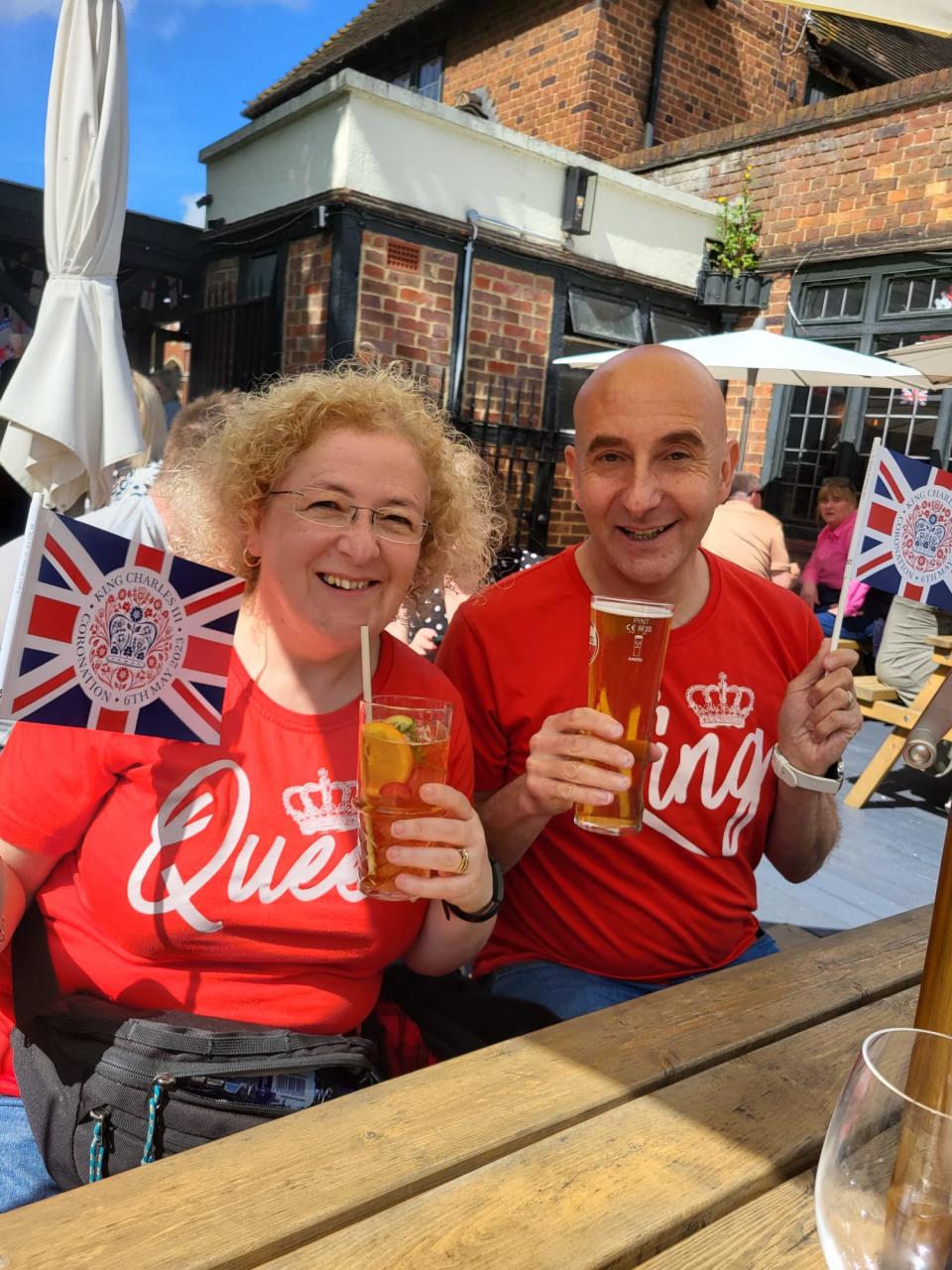 Man and woman with red t-shirts n and waving flags