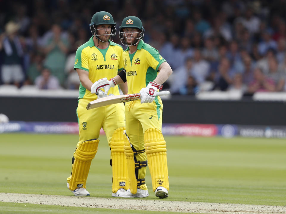 Australia's David Warner, right celebrates with teammate Australia's captain Aaron Finch after getting 50 runs not out during their Cricket World Cup match between England and Australia at Lord's cricket ground in London, Tuesday, June 25, 2019. (AP Photo/Alastair Grant)