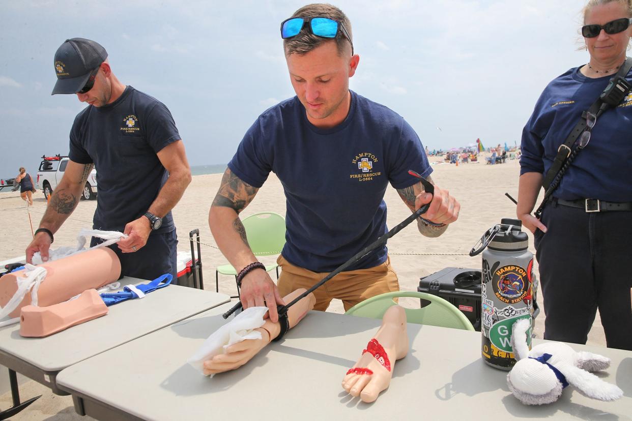 Hampton firefighter Alex Holmes demonstrates how to stop bleeding on a mannequin by using a tourniquet during Water Safety Day at Hampton Beach Thursday, July 27, 2023.