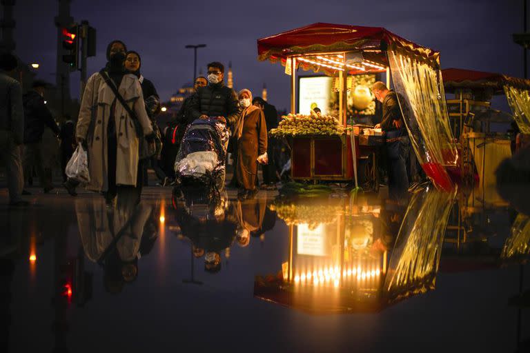 Un vendedor tuesta castañas y maíz mientras espera clientes en el distrito de Eminonu, en Estambul, Turquía